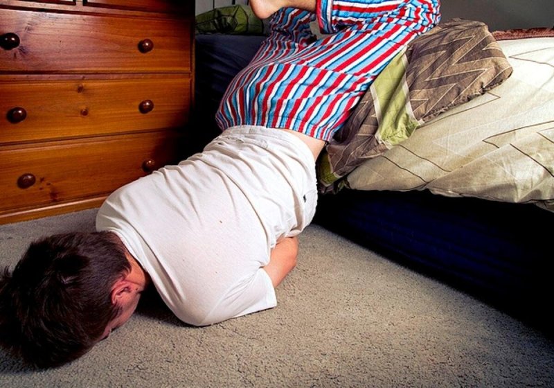 Человек свесился с кровати