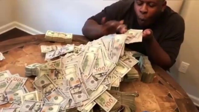 Негр лежит на деньгах