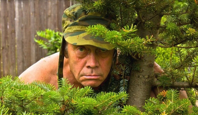 Человек прячется в кустах