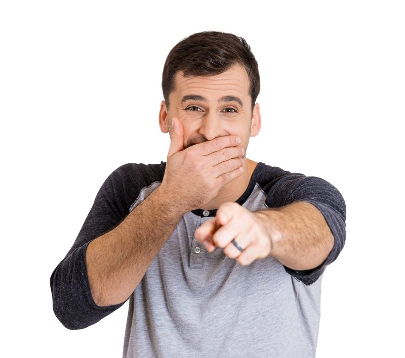 Показывает пальцем и смеется