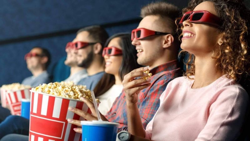 Человек в кинотеатре с попкорном