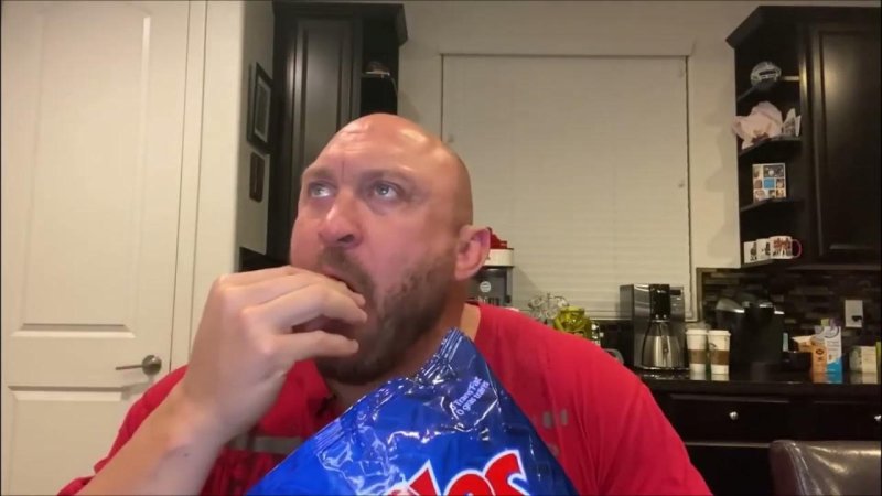 Лысый мужик ест чипсы