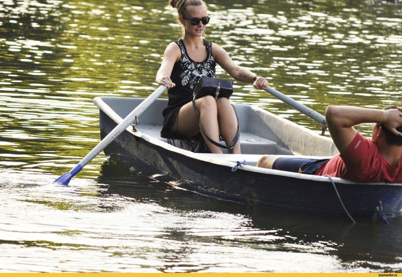 Гребет на лодке