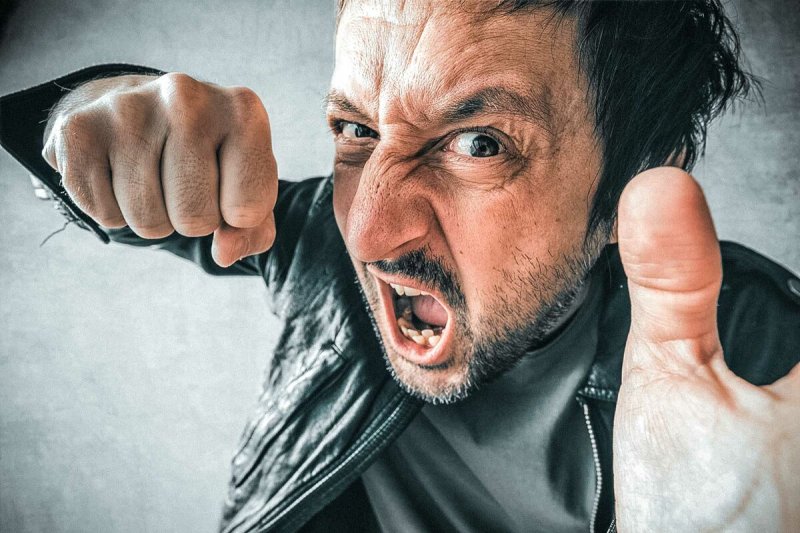 Человек замахивается кулаком