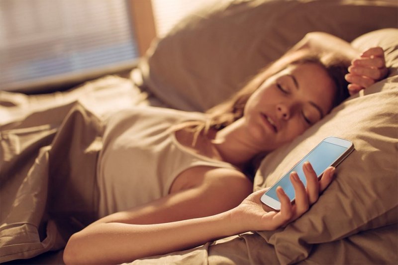 Девушка с телефоном в постели