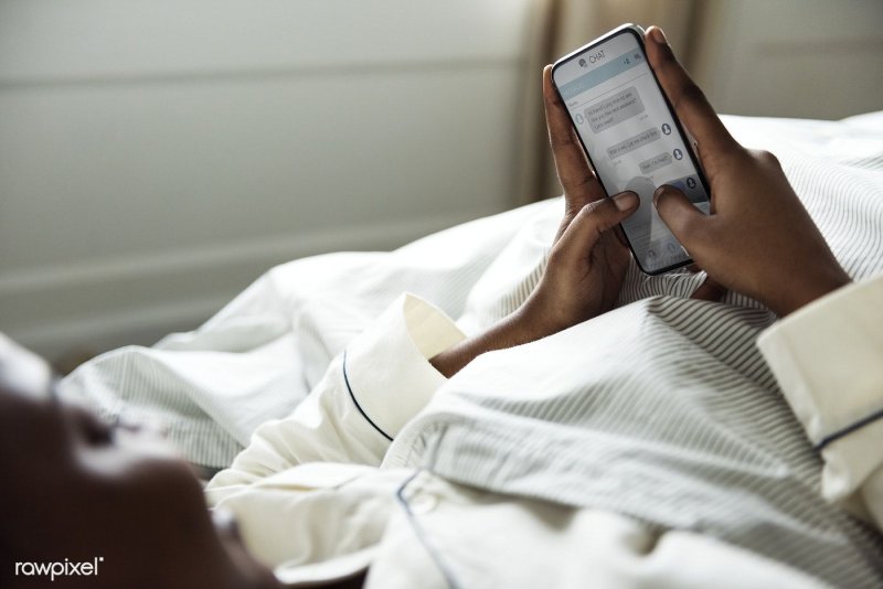 Человек с телефоном в кровати