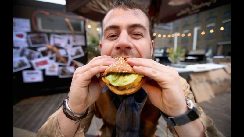 Человек ест гамбургер