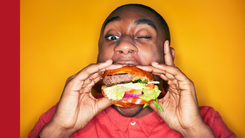 Человек ест бургер