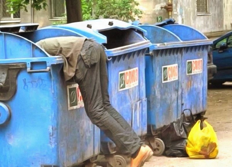 Бомж копается в мусорке