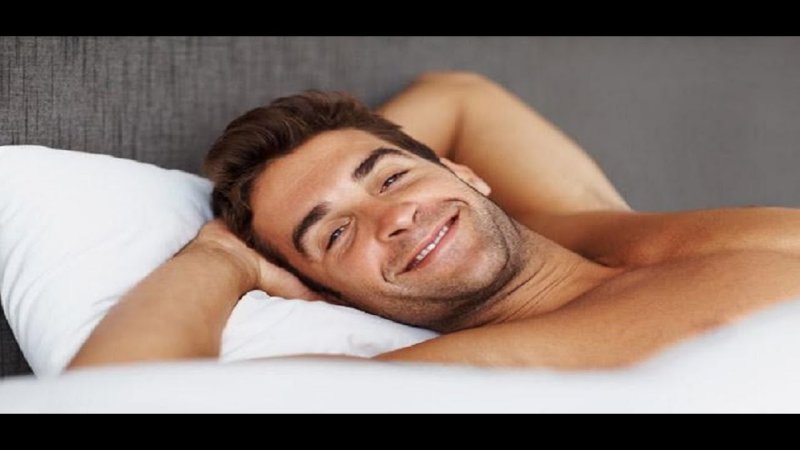 Парень улыбается в постели
