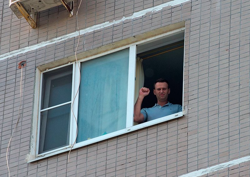 Человек выглядывает в окно