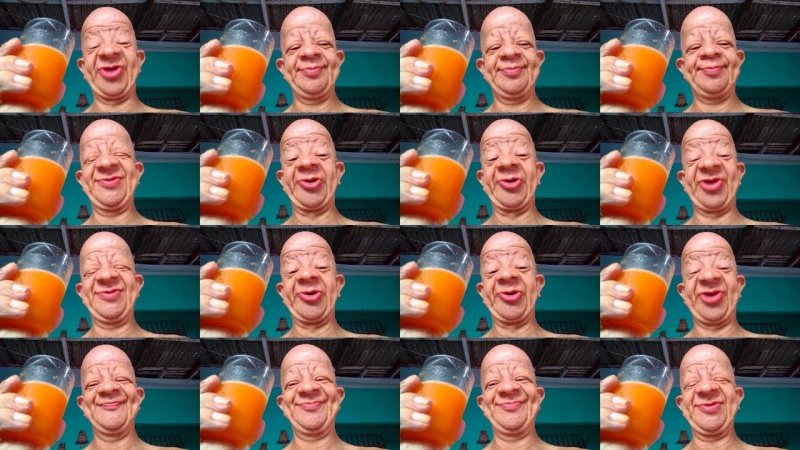 Лысый мужик пьет апельсиновый сок