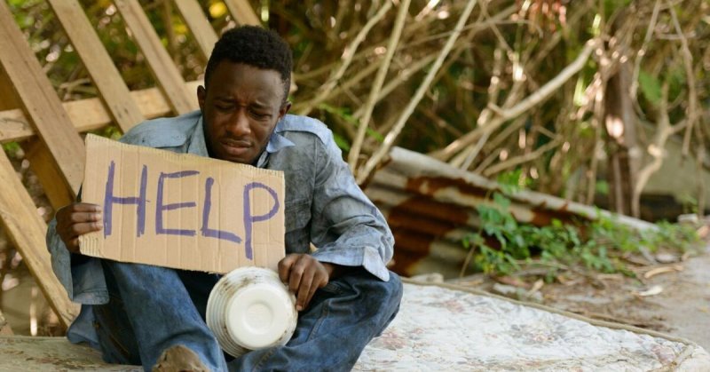 Негр с табличкой хелп