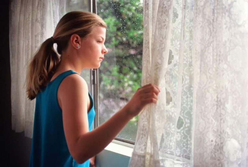 Девушка выглядывает в окно