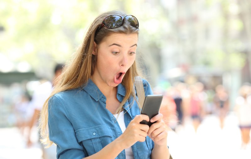 Удивленная девушка с телефоном