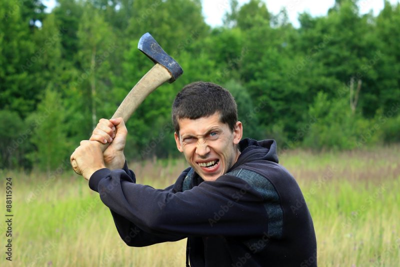 Мужчина замахивается топором