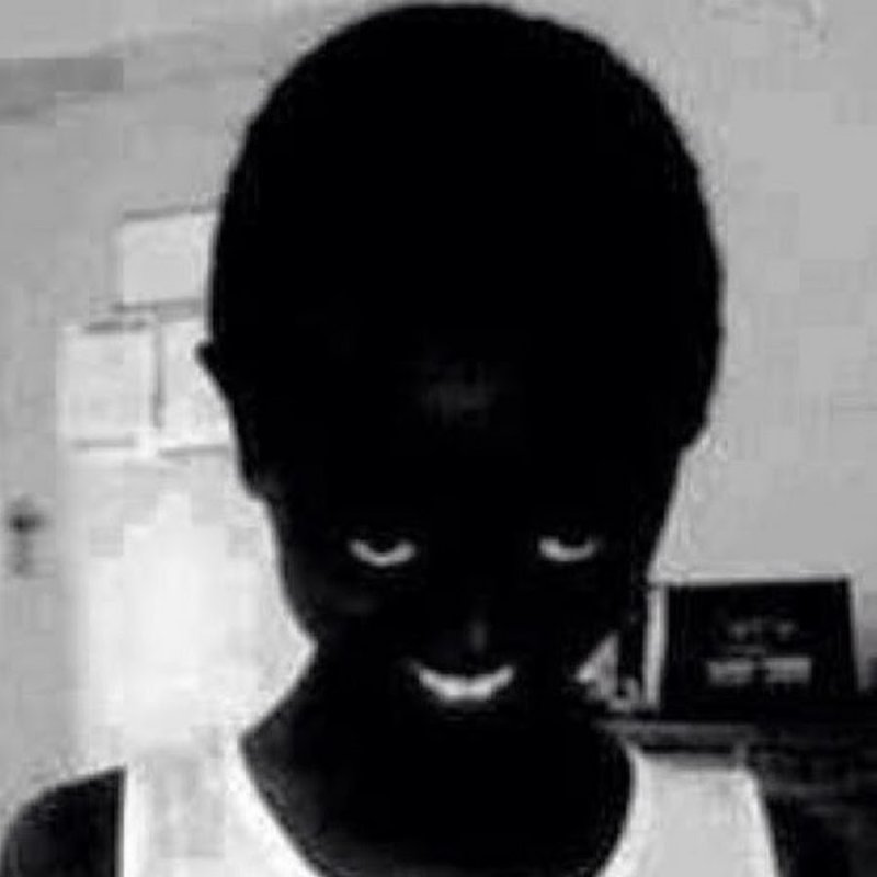 Негр улыбается в темноте