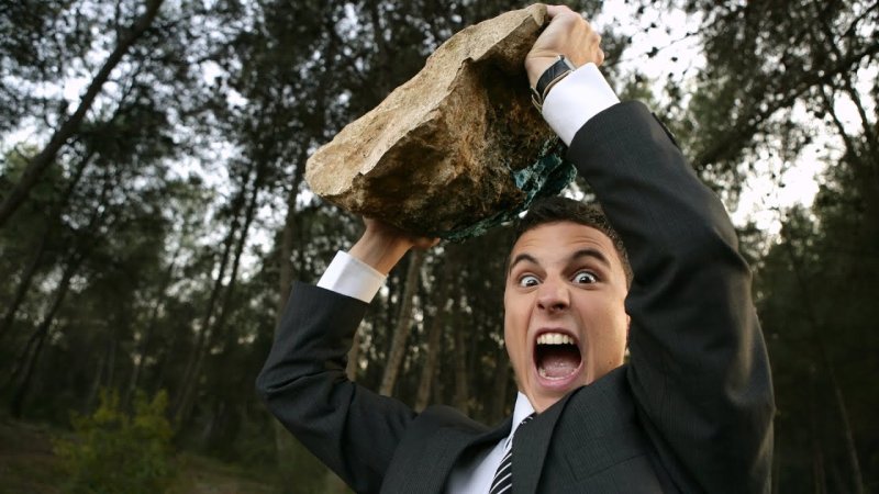 Мужчина с камнем в руке