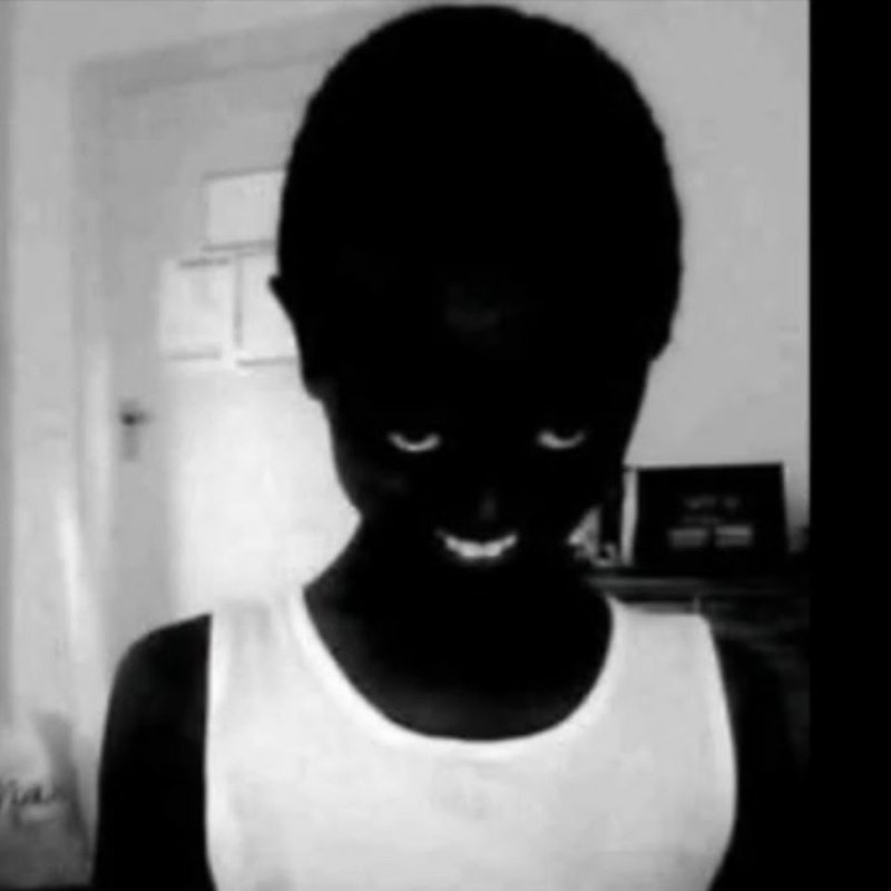 Негр улыбается в темно е