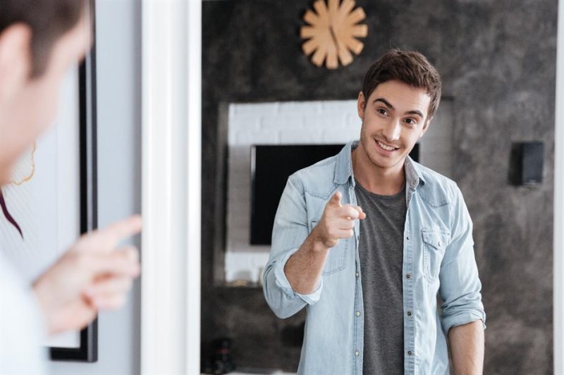 Мужчина улыбается в зеркало