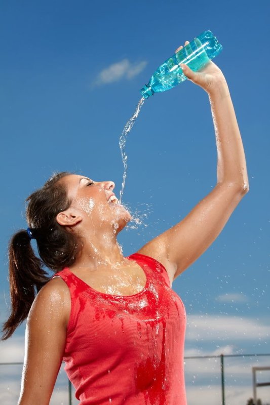 Девушка поливает себя водой из бутылки