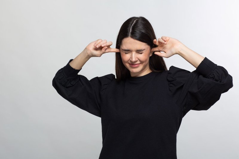 Женщина затыкает уши