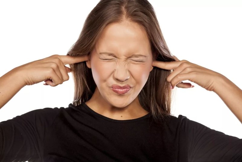 Девушка закрывает уши