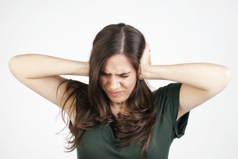 Человек закрывает уши