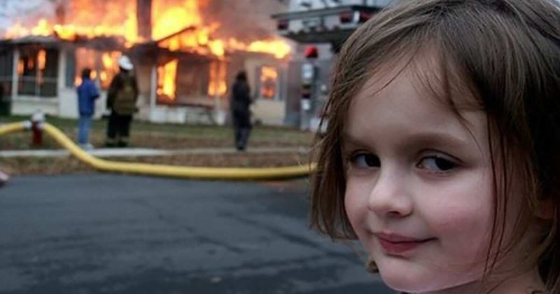 Девочка улыбается на фоне горящего дома