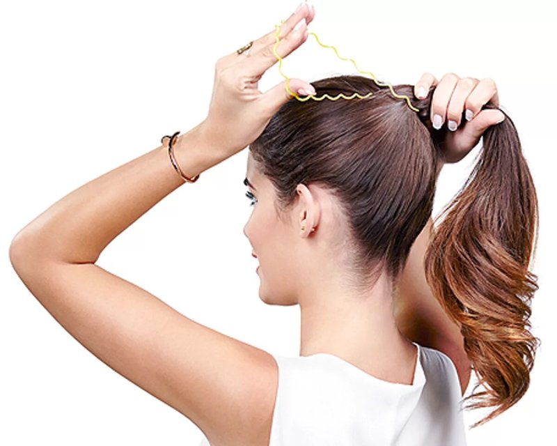 Девушка собирает волосы в хвост