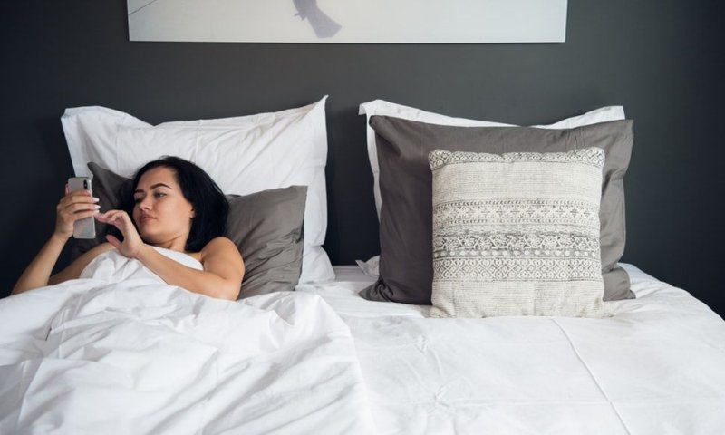 Девушка читает смс в кровати