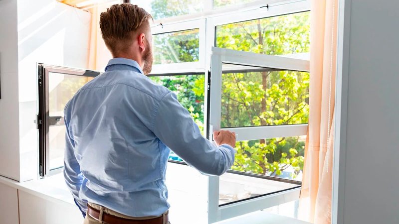 Человек открывает окно