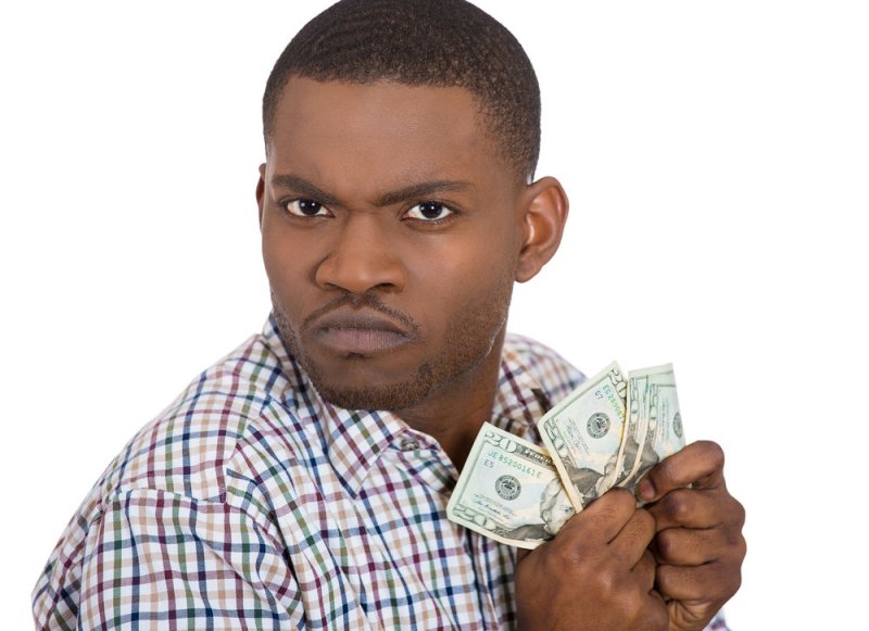 Афроамериканец держит доллары