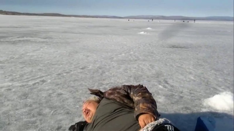 Толстый мужик лежит на снегу