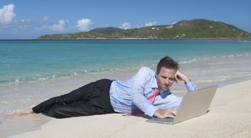 Человек с ноутбуком на пляже
